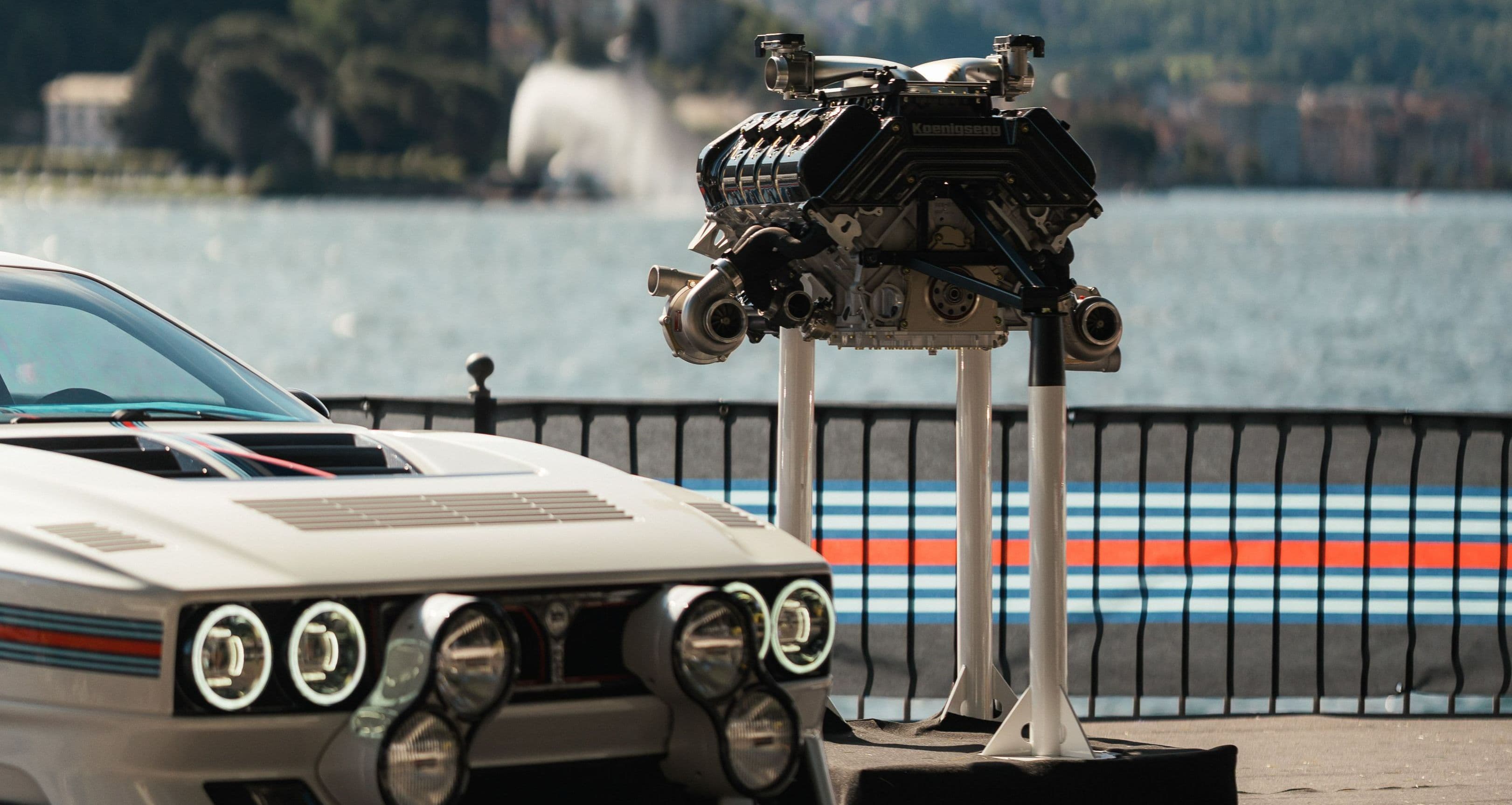 Kimera Automobili com decoração Martini e o motor em exposição junto a um lago